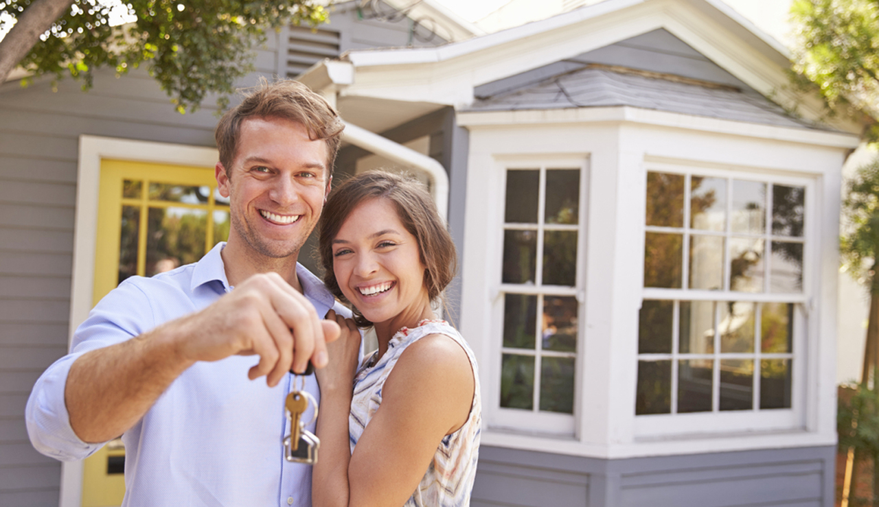 Couple,With,Keys,Standing,Outside,New,Home