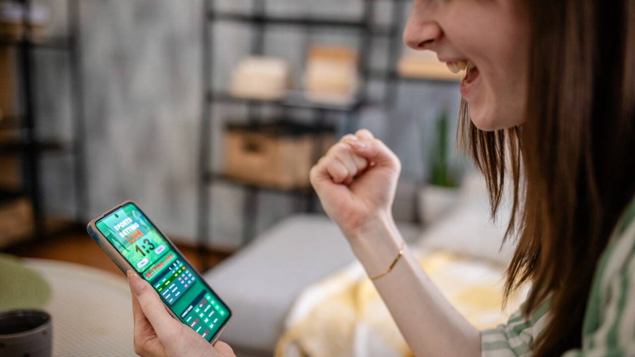 Excited woman checks smartphone for winning result