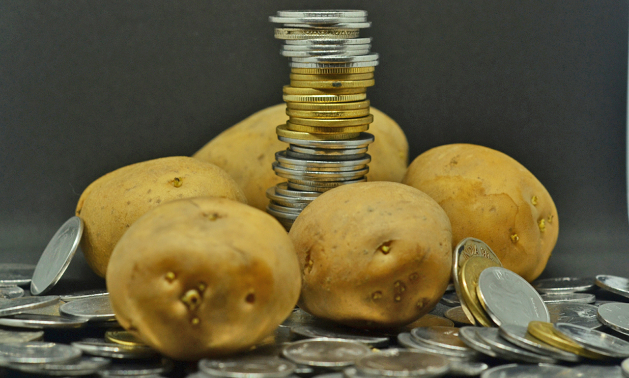 Raw,Potatos,In,Dark,Background,With,Piled,Indian,Rupee,Coins