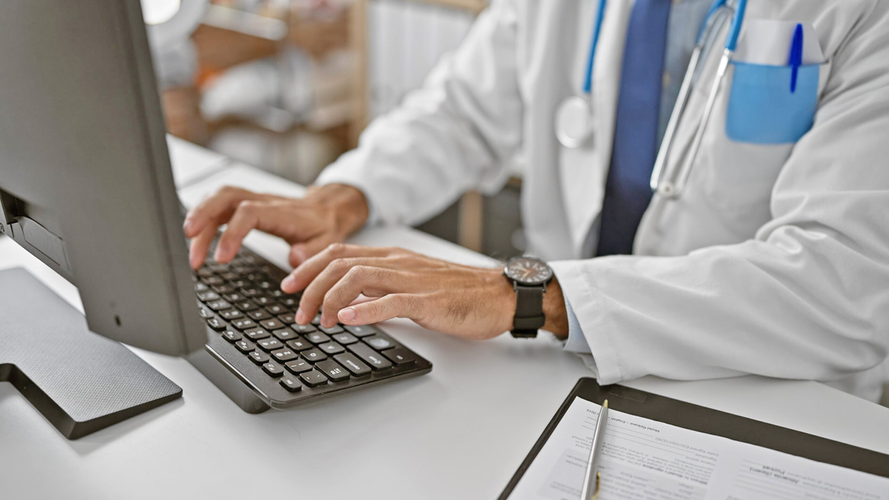 Young,Hispanic,Man,Doctor,Using,Computer,Working,At,The,Clinic