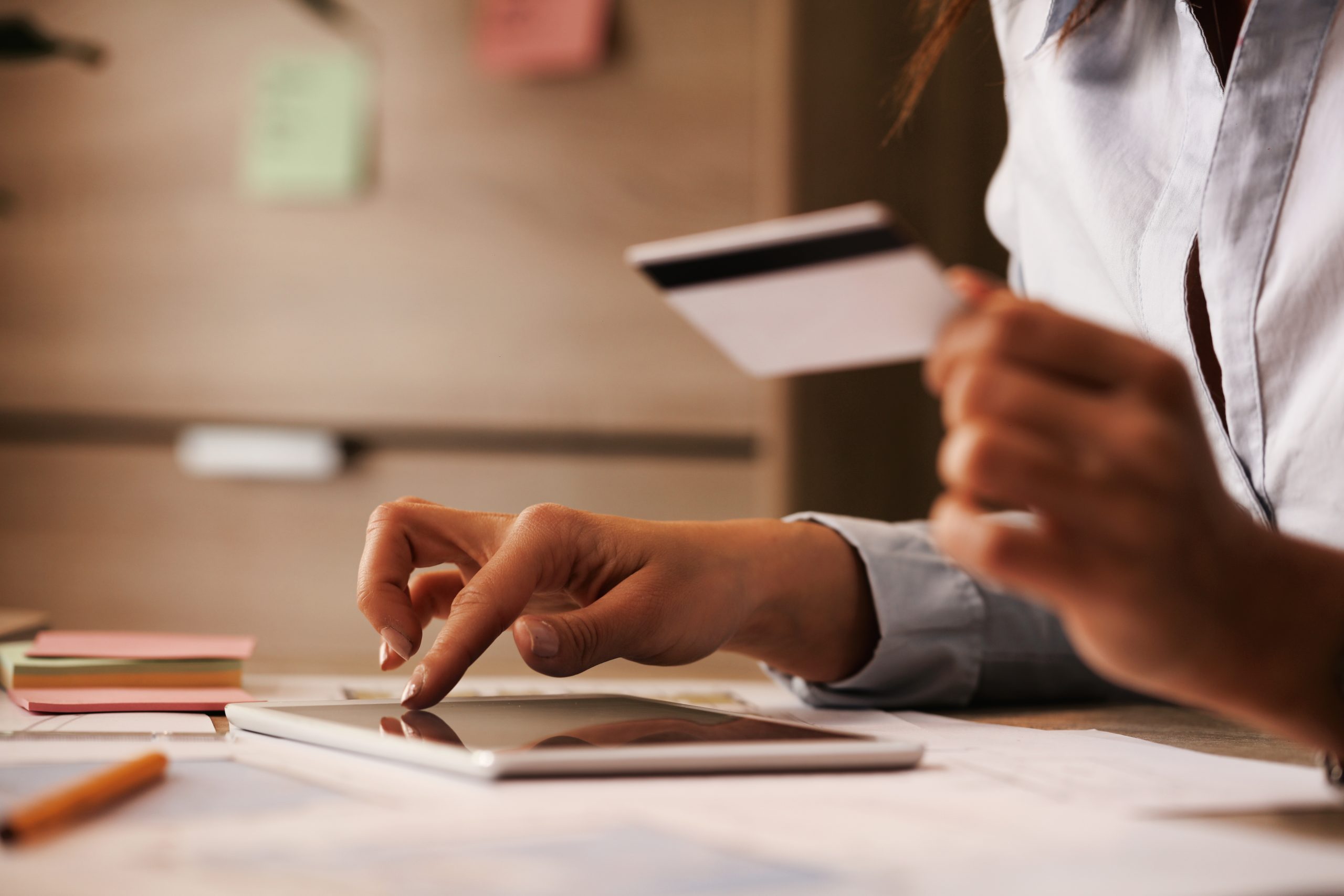 Close-up of businesswoman using touchpad and credit card while b